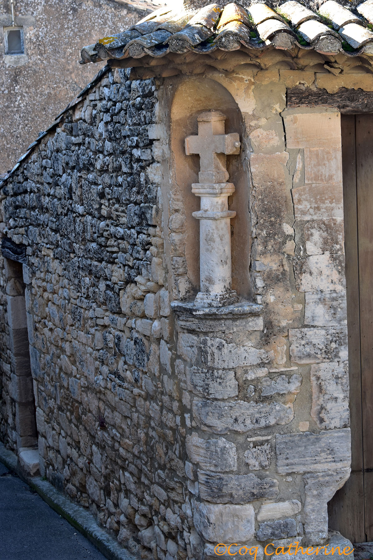 sculpture d'une croix dans une niche d'un mur